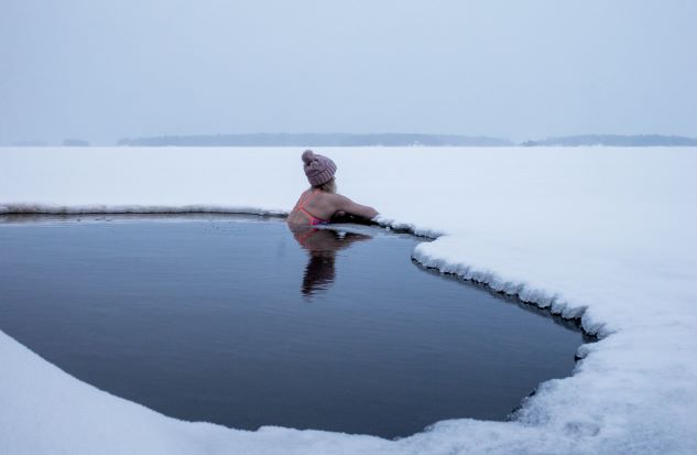 žena otužijící se ve studené vodě v rybníce